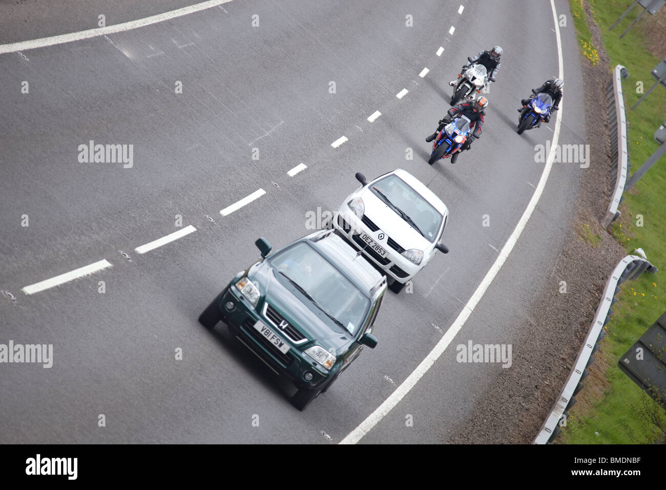 Motocicli motocicli dietro il traffico di automobili su una curva del A75 road vicino a Castle Douglas Regno Unito Foto Stock