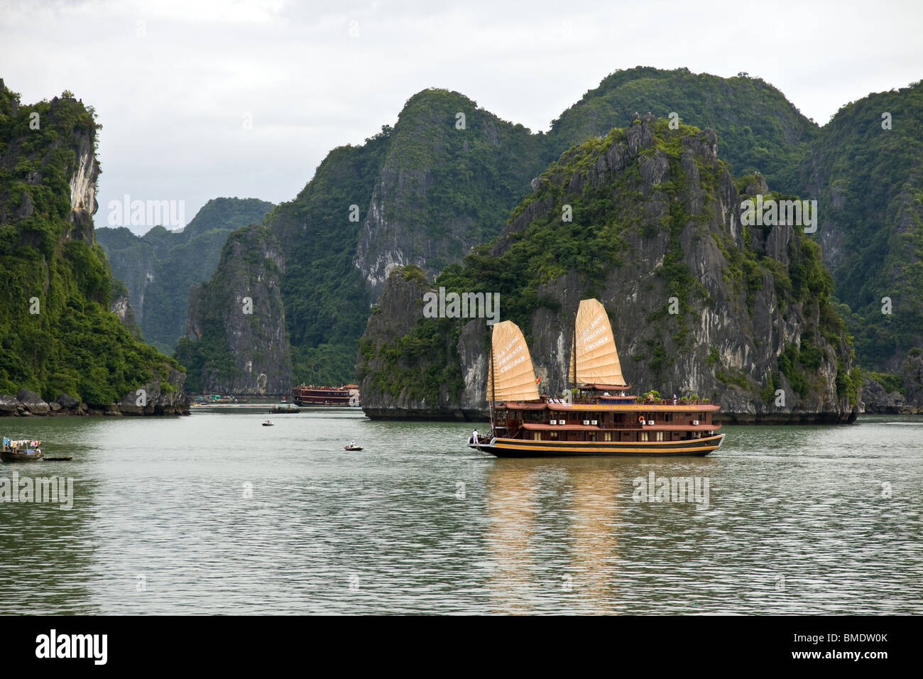 Junk nave accoccolato tra le isole rocciose della baia di Halong, Vietnam Foto Stock