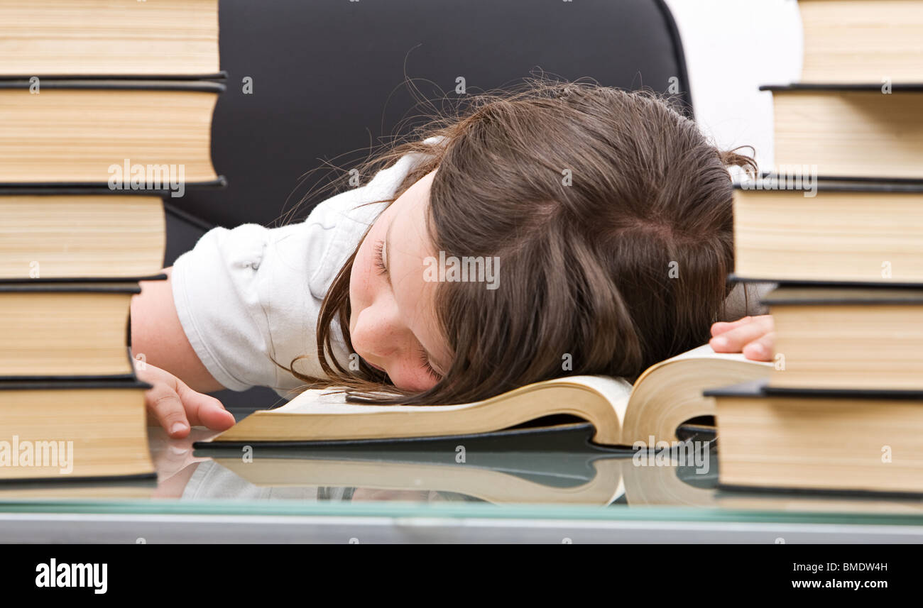 Colpo di una giovane ragazza addormentata sui suoi libri mentre studiano Foto Stock