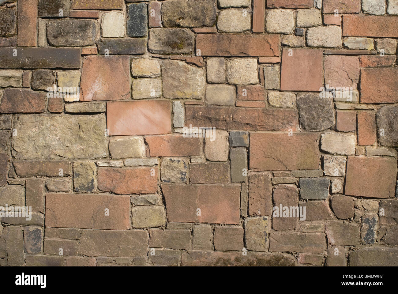 Un solido muro di pietra di pietra arenaria calcare e granito. Foto Stock