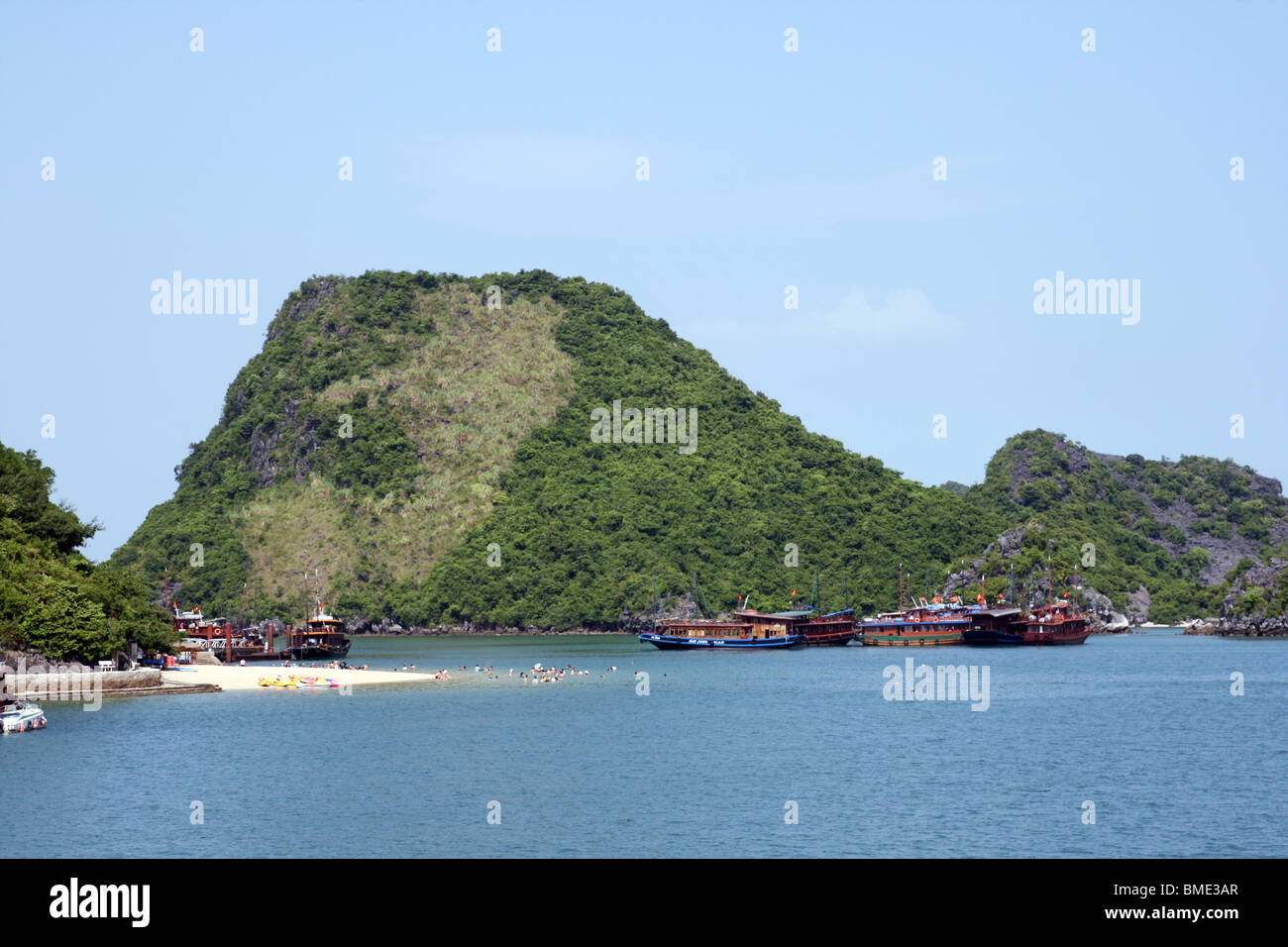 Junkboats e la spiaggia nella baia di Halong, Vietnam Foto Stock