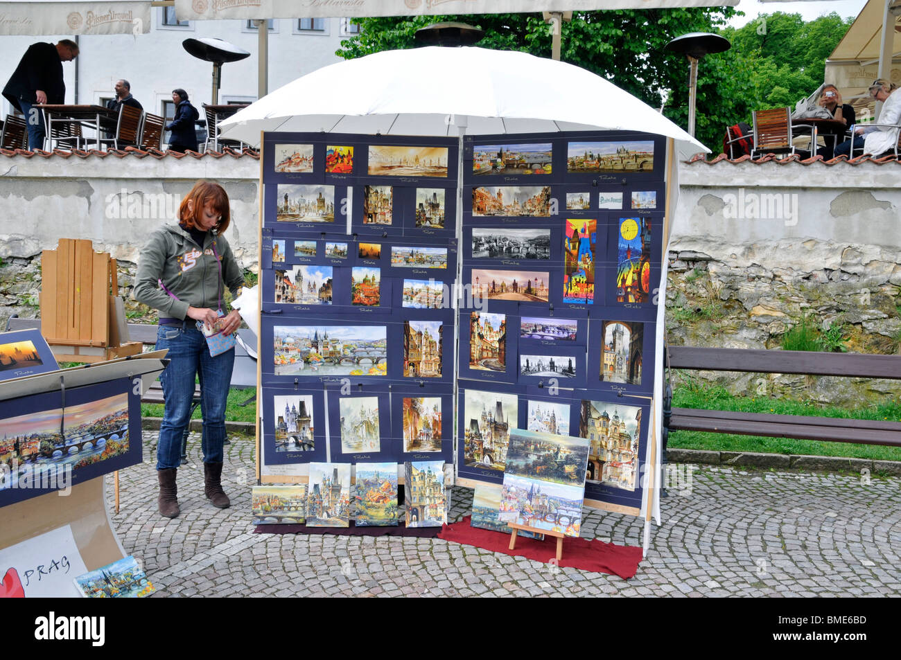 Giovane donna graziosa soggiornando vicino stand con immagini di Praga, Repubblica Ceca ,l'Est Europa Foto Stock