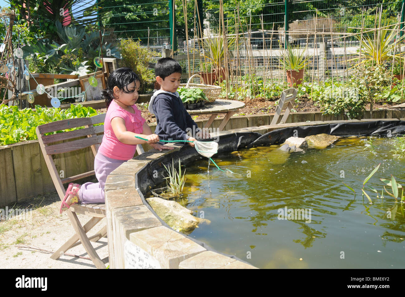 UK BENGALI bambini che giocano al laghetto a SPITALFIELDS CITY FARM A LONDRA Foto Stock