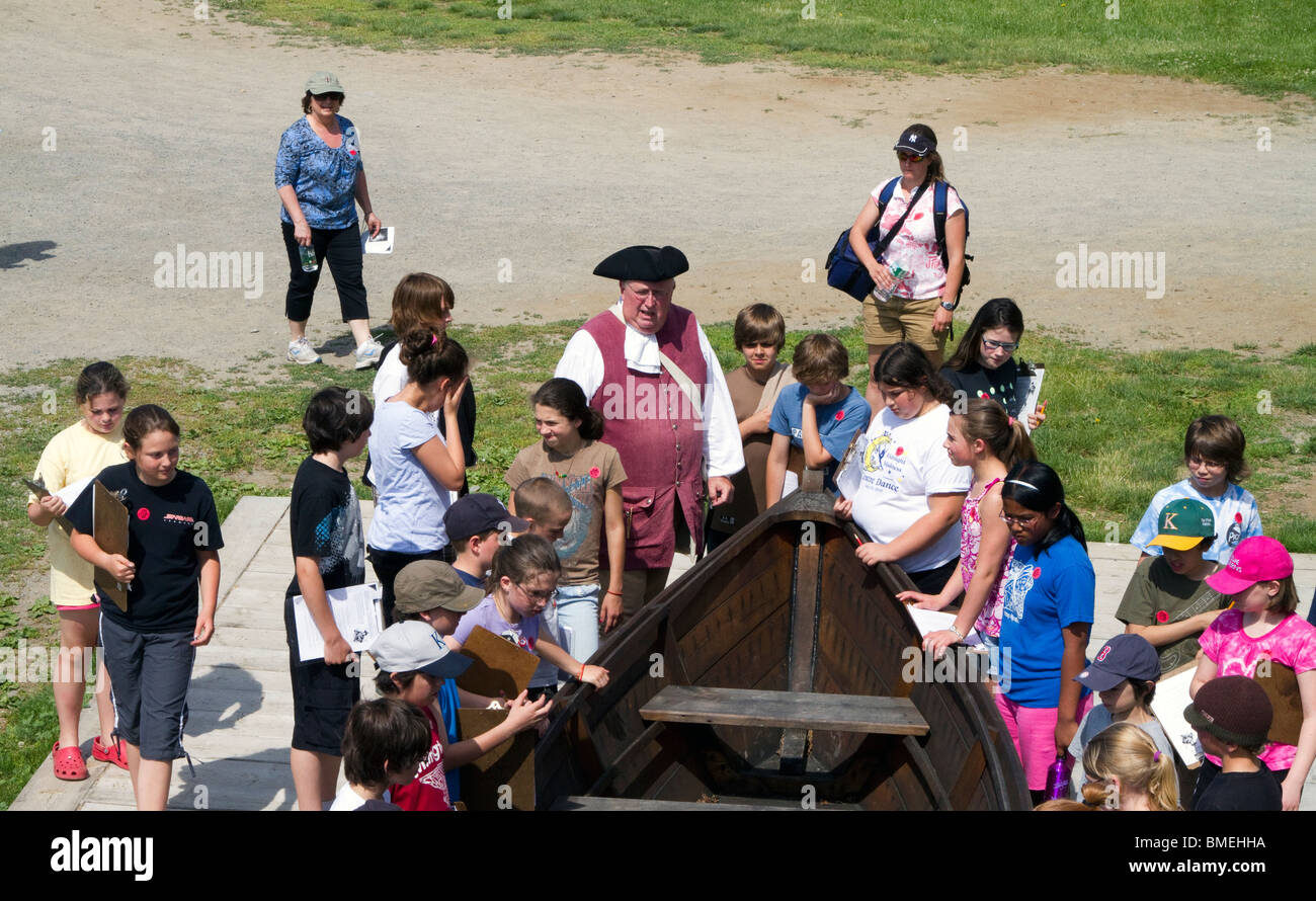 Un periodo vestito in costume a guida Fort Ticonderoga, New York con un gruppo di bambini. Insegnamento e lettura. Foto Stock