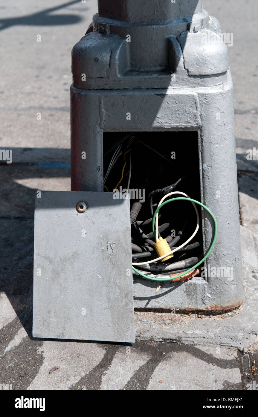 Un quadro elettrico su una strada di luce espone cablaggio pericolose per il pubblico in generale. Foto Stock