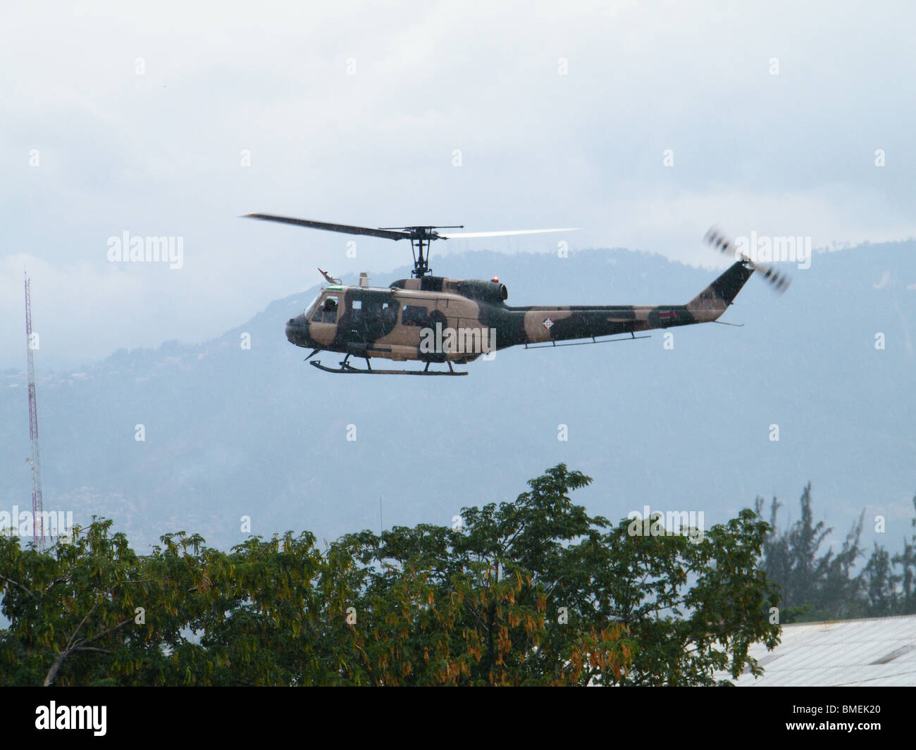 Un elicottero militare fornire aiuti vola sopra Port au Prince dopo il terremoto di Haiti Foto Stock