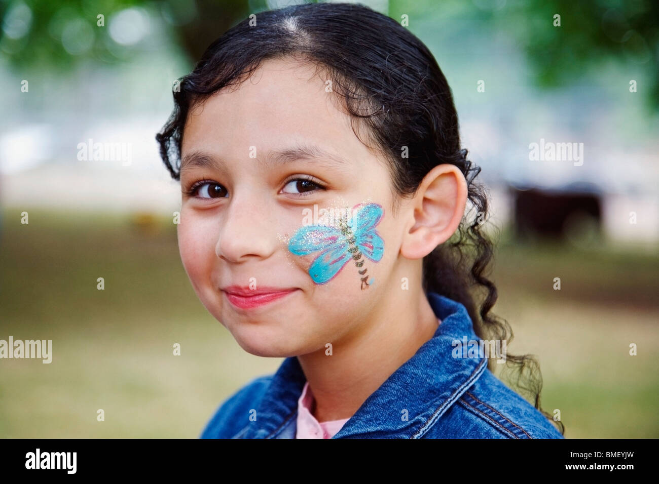 Una ragazza con una farfalla dipinta sul suo viso Foto Stock