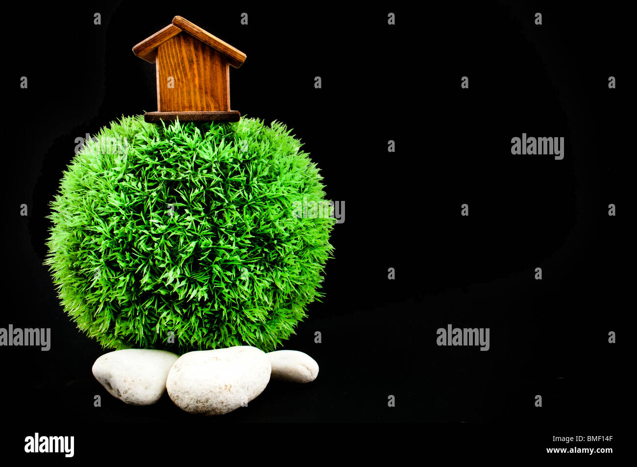 Casa in legno sul mondo sempreverde con pietre bianche Foto Stock