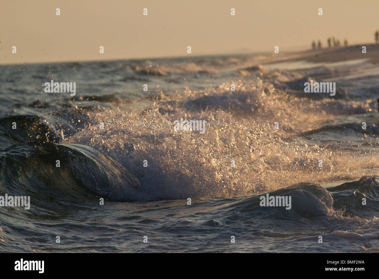 Le onde che si infrangono al tramonto Foto Stock