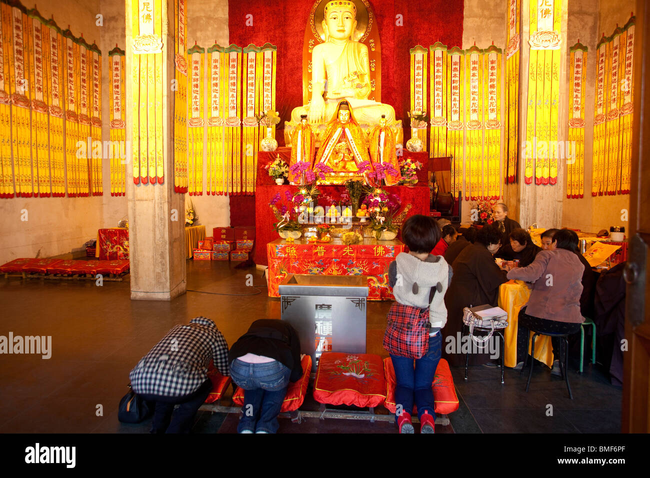 Buddisti adorare in Mahavira Palace, tempio di Jing'an, Shanghai, Cina Foto Stock