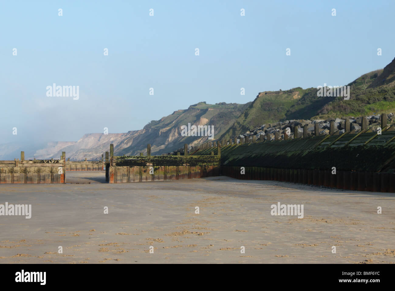 Miglia di pulire non affollata spiaggia a Overstrand, NORFOLK REGNO UNITO mostra le difese del mare e coste tipico per questa zona. Foto Stock