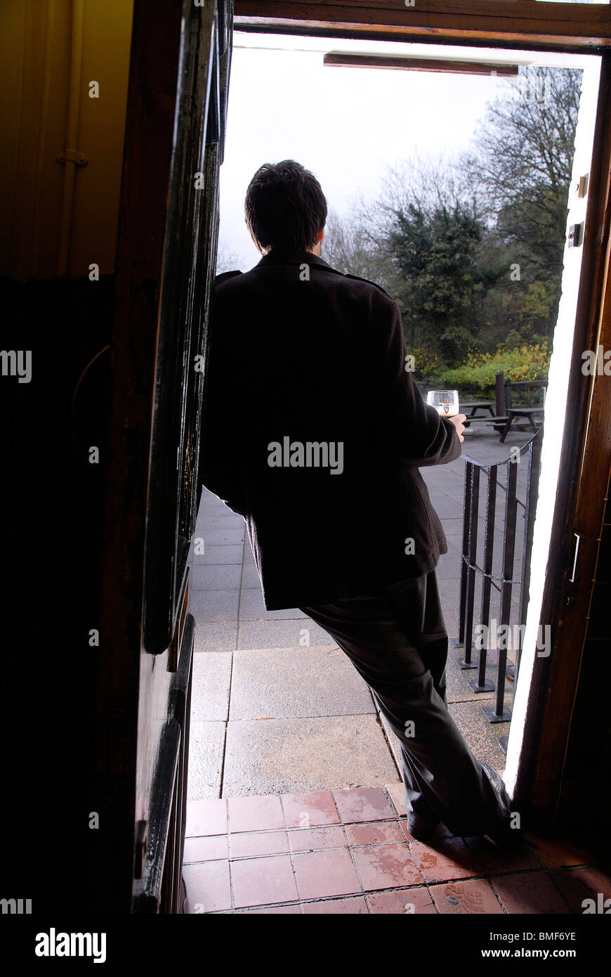 Un cliente sta alla porta di Crooked House pub in Himley, Gornal legno, West Midlands Foto Stock