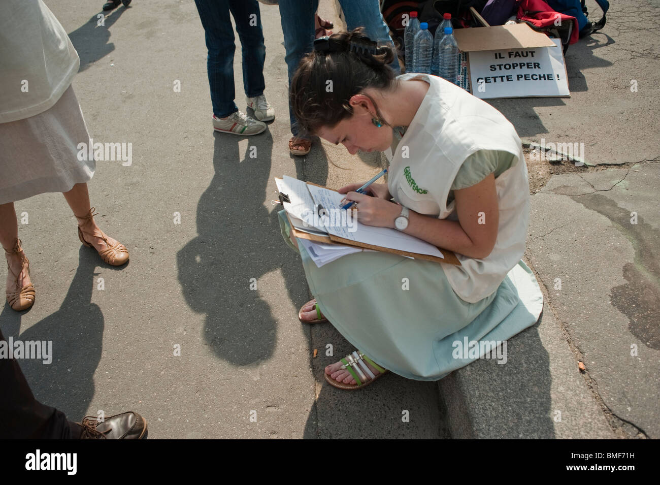 Gli ambientalisti di Greenpeace che manifestano contro il tonno rosso Pesca, Giornata nazionale di protesta, Parigi, Francia, Donna Firma la petizione Foto Stock