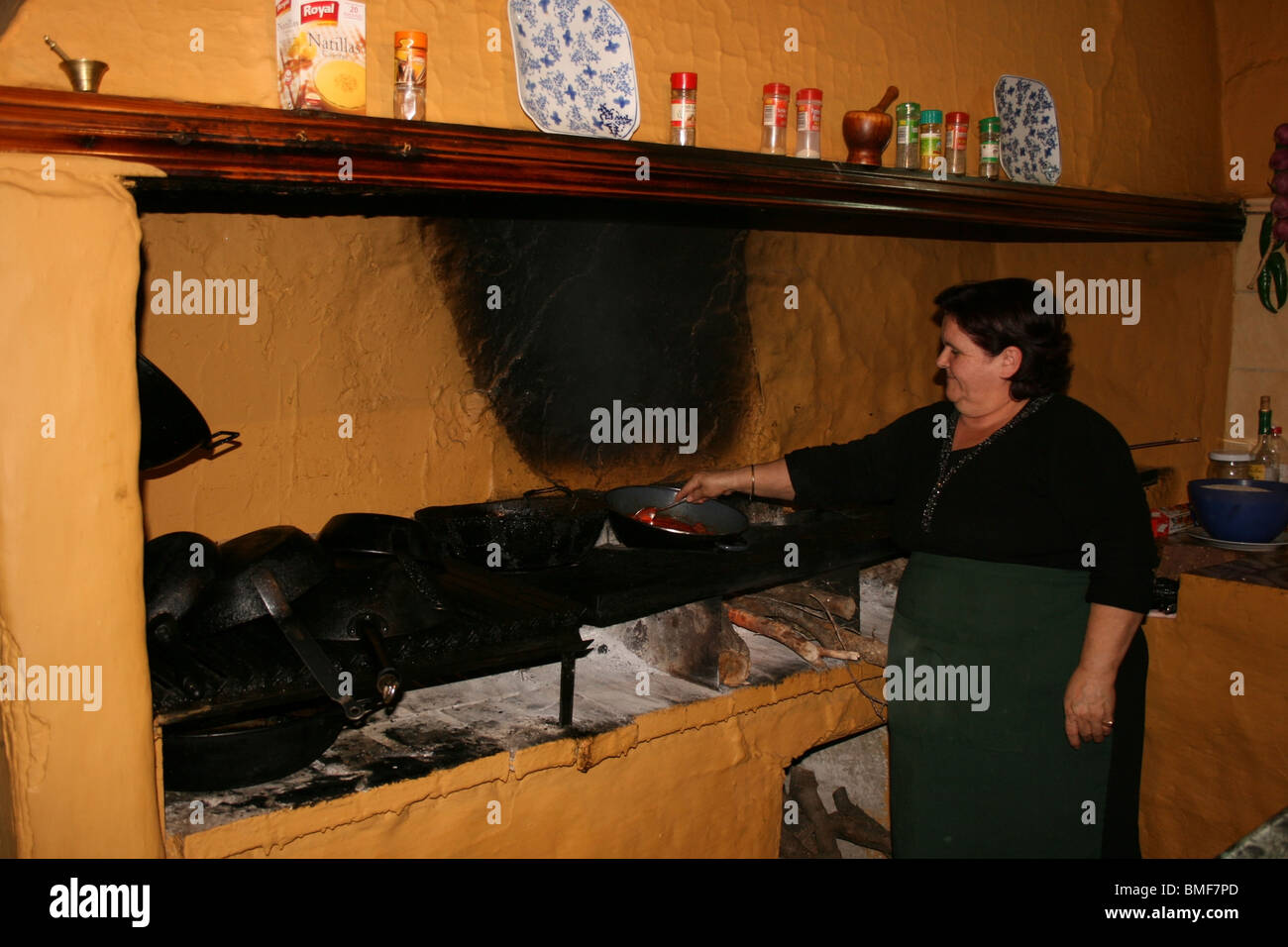 Donna spagnola per la cottura sul vecchio stile a legna per intervallo. Foto Stock