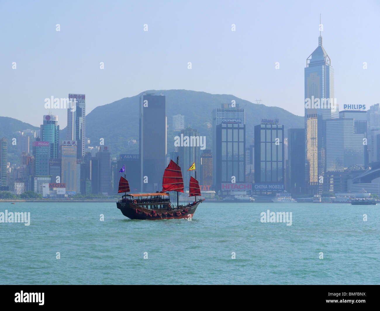 Junk barca che scivola dalla baia di Victoria nella superficie anteriore della Hong Kong skyline di grattacieli, Cina Foto Stock