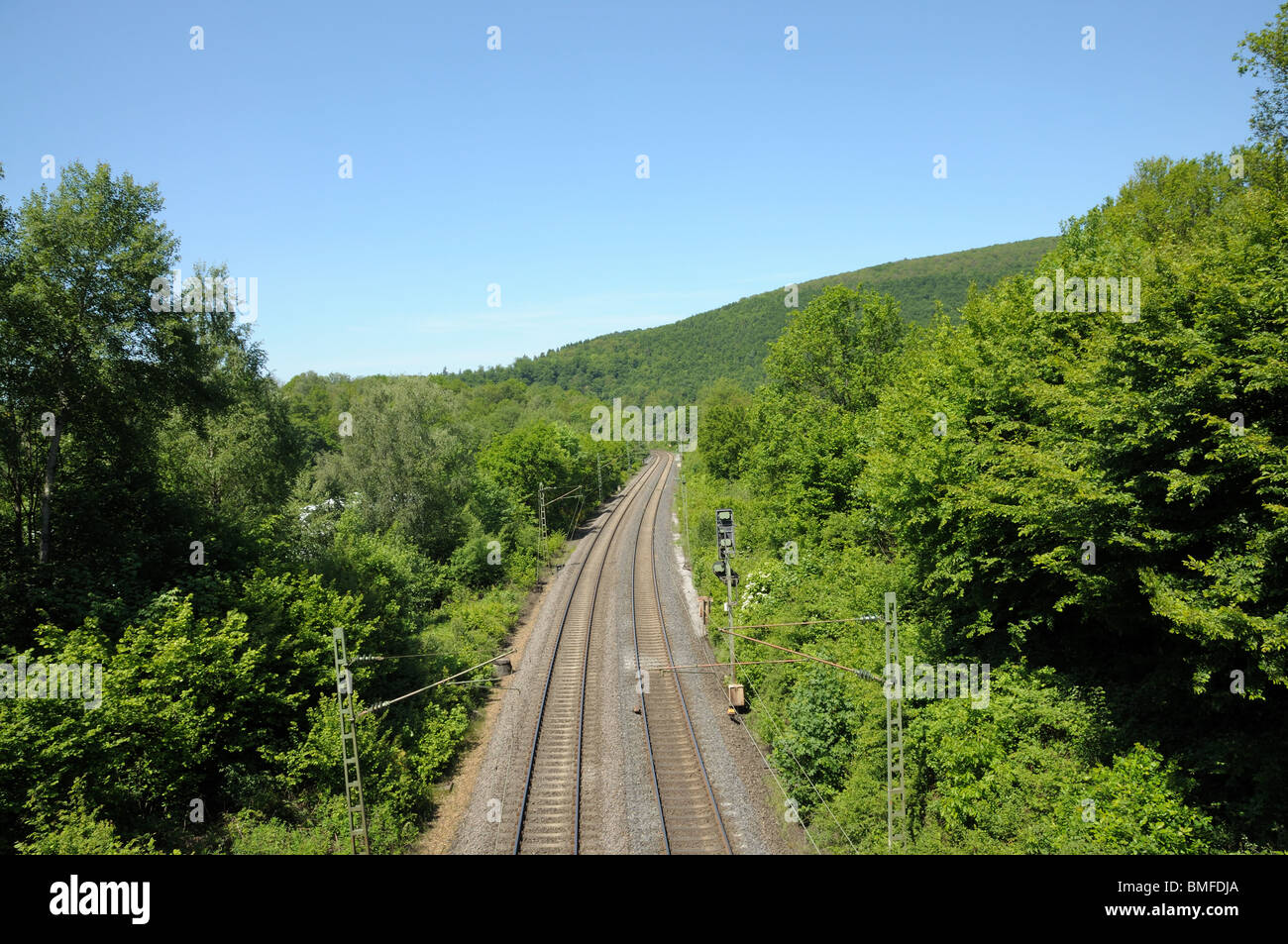 Ferrovia via in esecuzione attraverso un paesaggio verde Foto Stock