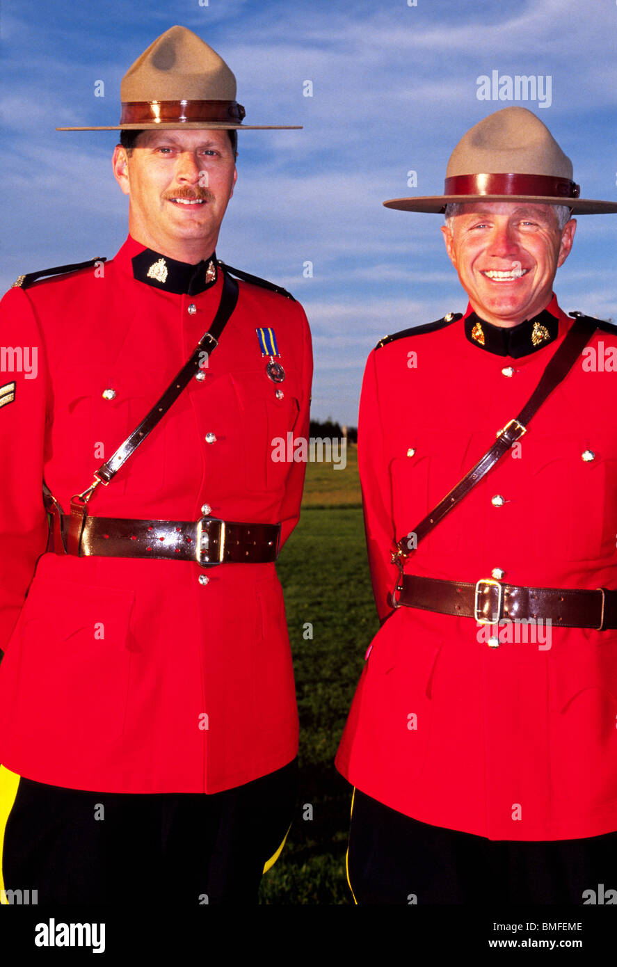 Due sorridente Royal Canadian polizia montata nel loro tradizionale rosso brillante Serge vestito giacche uniforme in New Brunswick, Canada. Foto Stock
