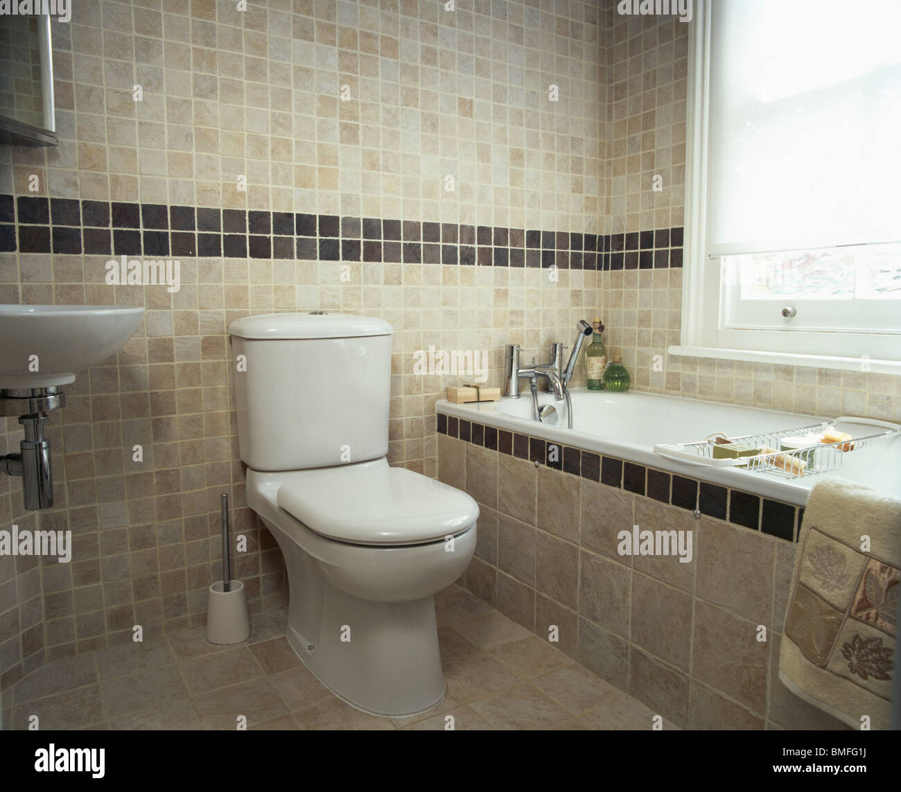 Servizi igienici a fianco di vasca da bagno con piastrelle in surround beige  moderno bagno piastrellato con mattonelle nere confine sulla parete Foto  stock - Alamy