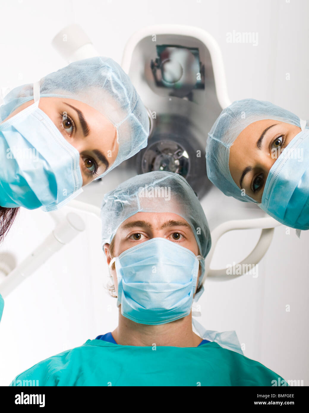 Il team di professionisti medici guardando giù al paziente in sala operatoria Foto Stock