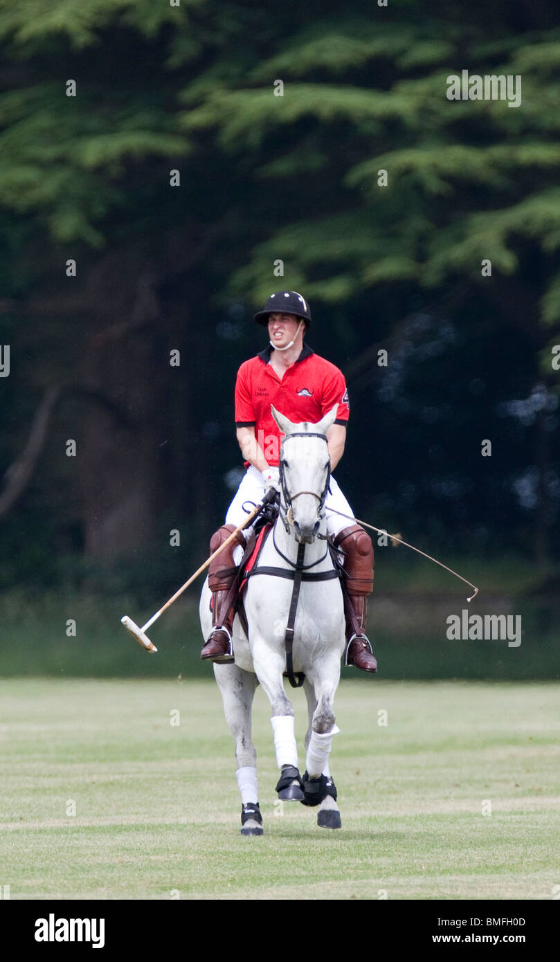 La Gran Bretagna è il principe William giocando in rosso numero 4 per il polo team Umbogo a Cirencester Parl in Gloucestershire Foto Stock