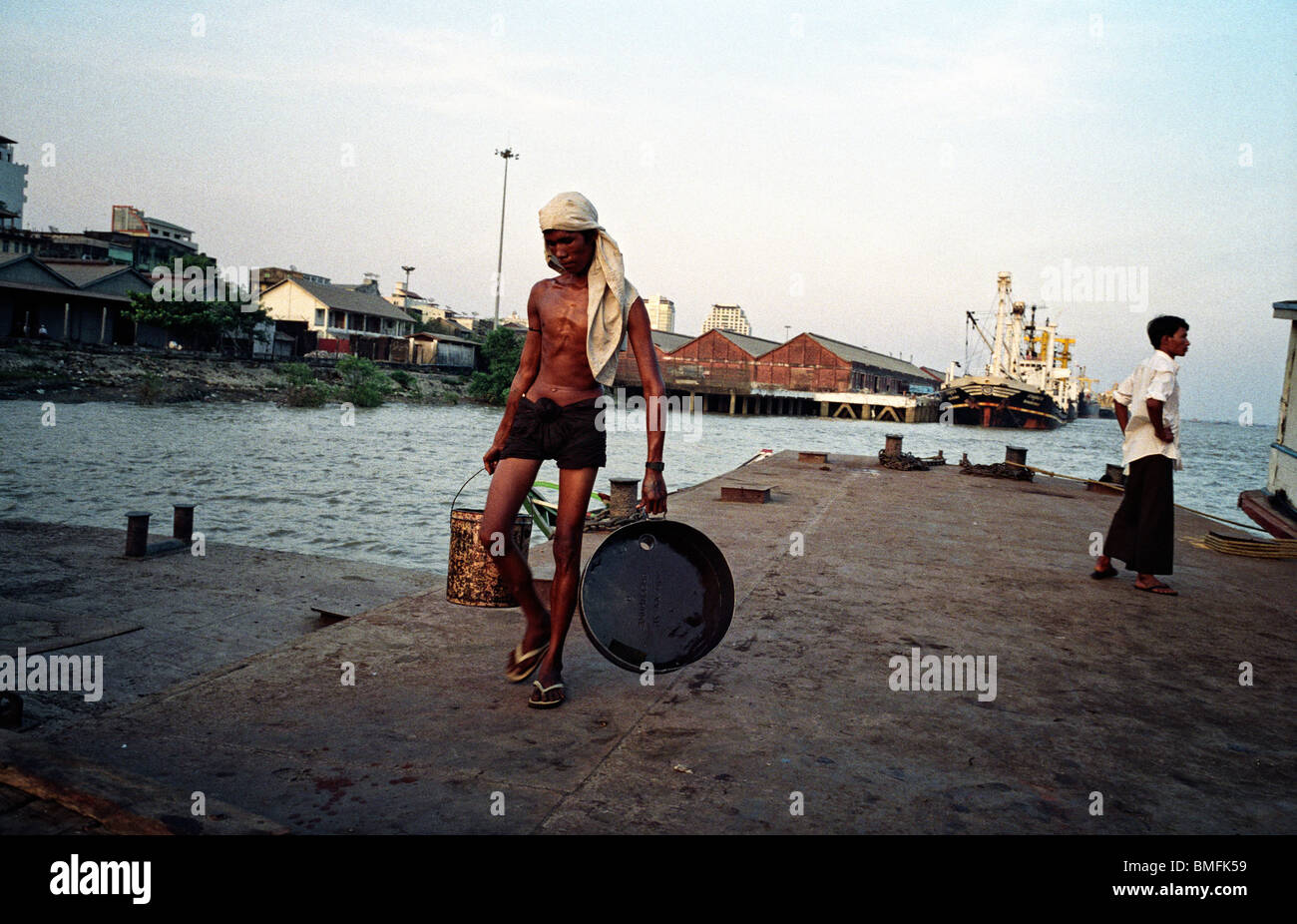 Un dockworker su un molo sul fiume Yangon a Yangon, Maggio 2010 Foto Stock