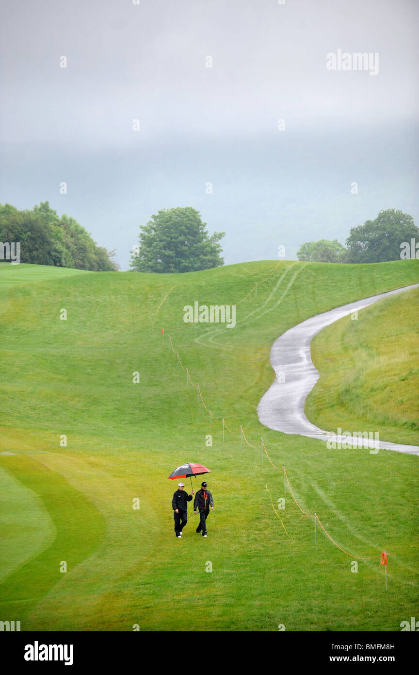 Un giocatore di golf e il suo allenatore a piedi il corso sotto la pioggia al Celtic Manor Wales Open 2008 Foto Stock