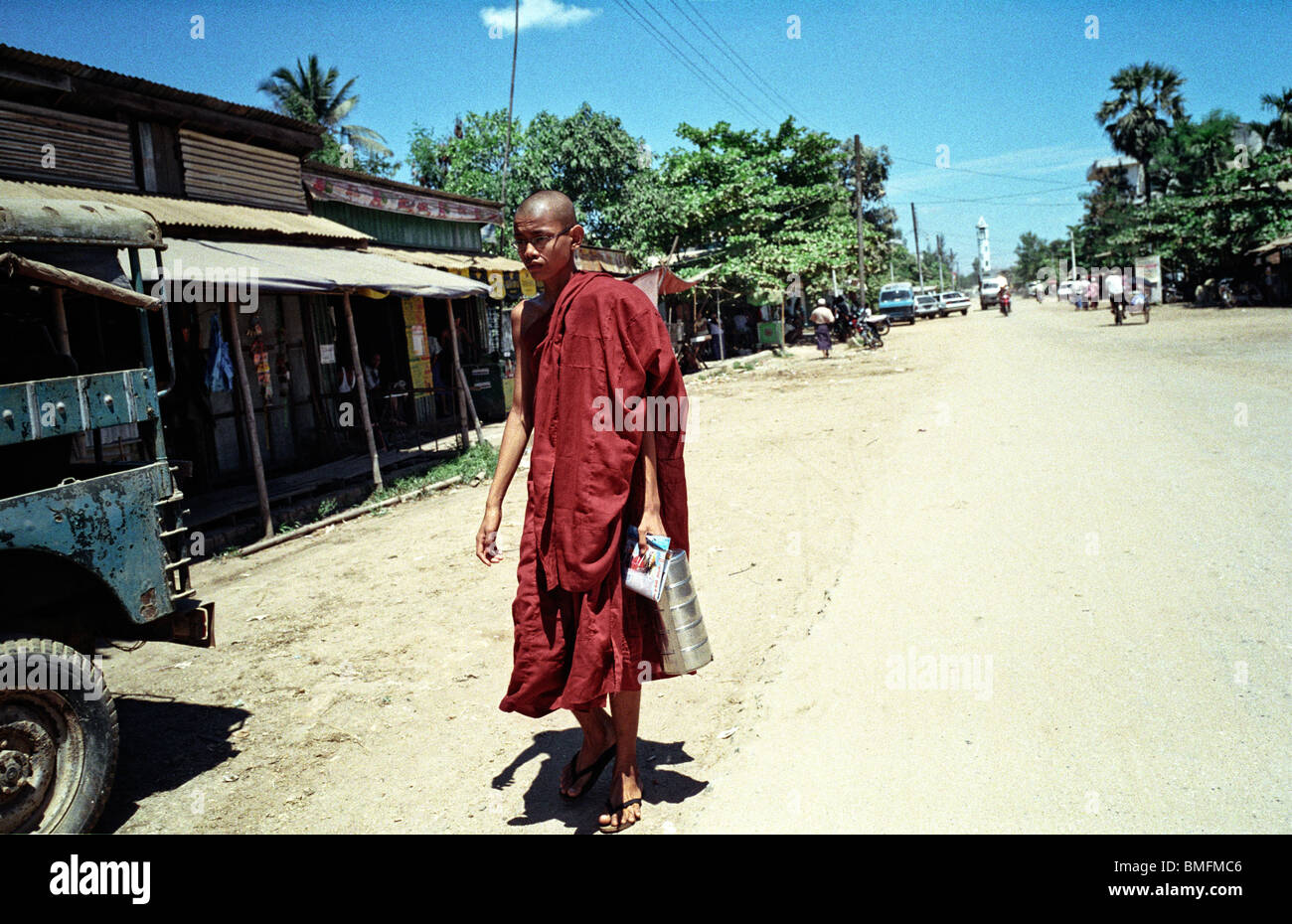 Un giovane monaco passeggiate lungo la strada principale di Twante, nel fiume Yangon Delta, Myanmar Maggio 2010 Foto Stock