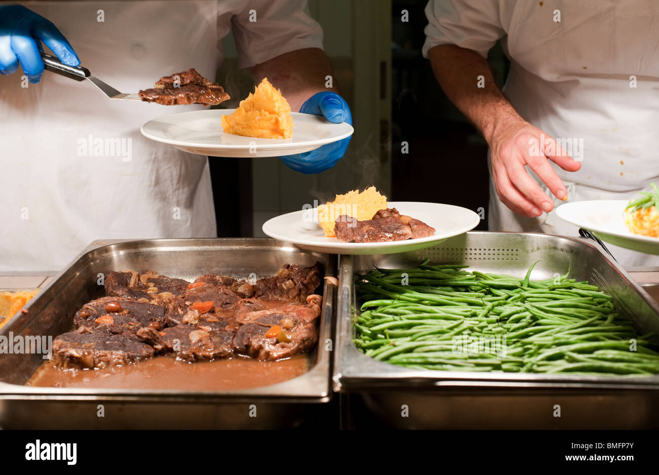 Brasato di manzo servita con purè di patate dolci e fagioli verdi formale a cena presso un College di Oxford Foto Stock