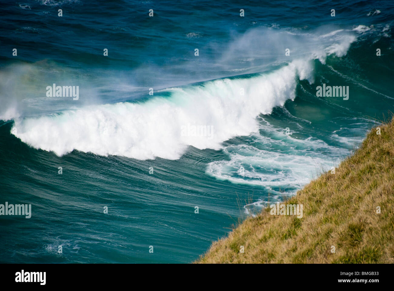 Onde circa a schiacciare sulla scogliera Foto Stock