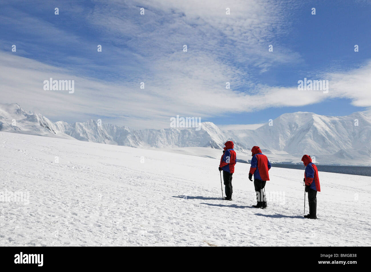 I turisti con giacche rosse in piedi nel punto Damoy, isola Wiencke, Palmer arcipelago, Antartide Foto Stock