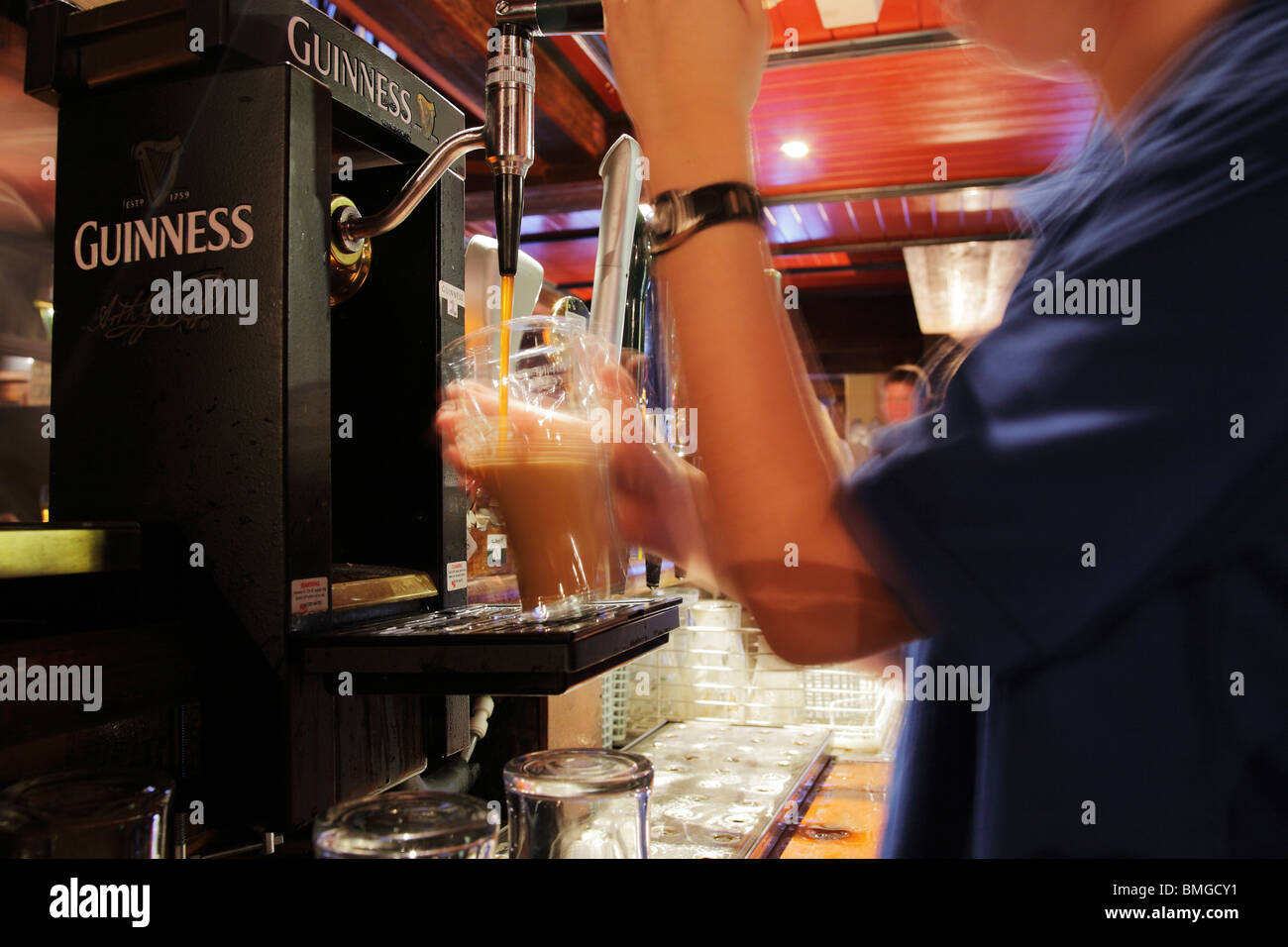 Barman versando una pinta di Guinness al King's Bar di Clifden, Irlanda Foto Stock