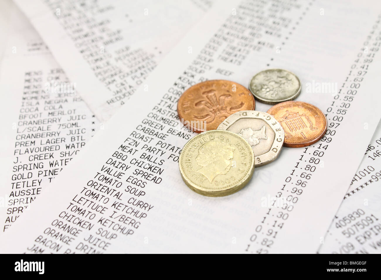 Monete sparse lungo un supermercato shopping bill Foto Stock