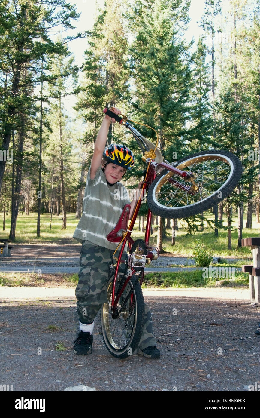 Il Parco Nazionale di Banff, Alberta, Canada; un ragazzo gioca con la sua bicicletta in un campeggio Foto Stock