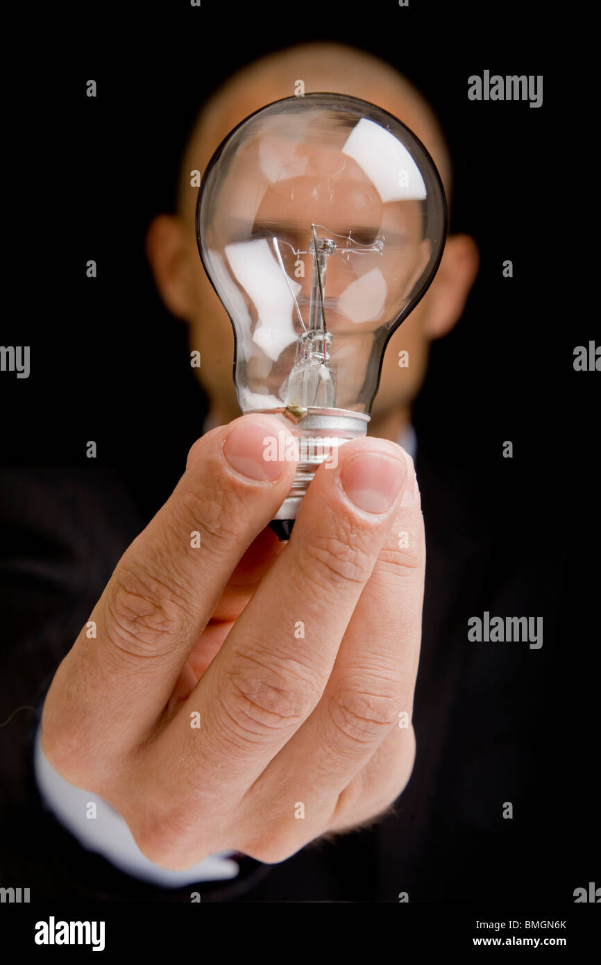 Uomo con una lampadina fino davanti al suo volto come un concetto idea Foto Stock