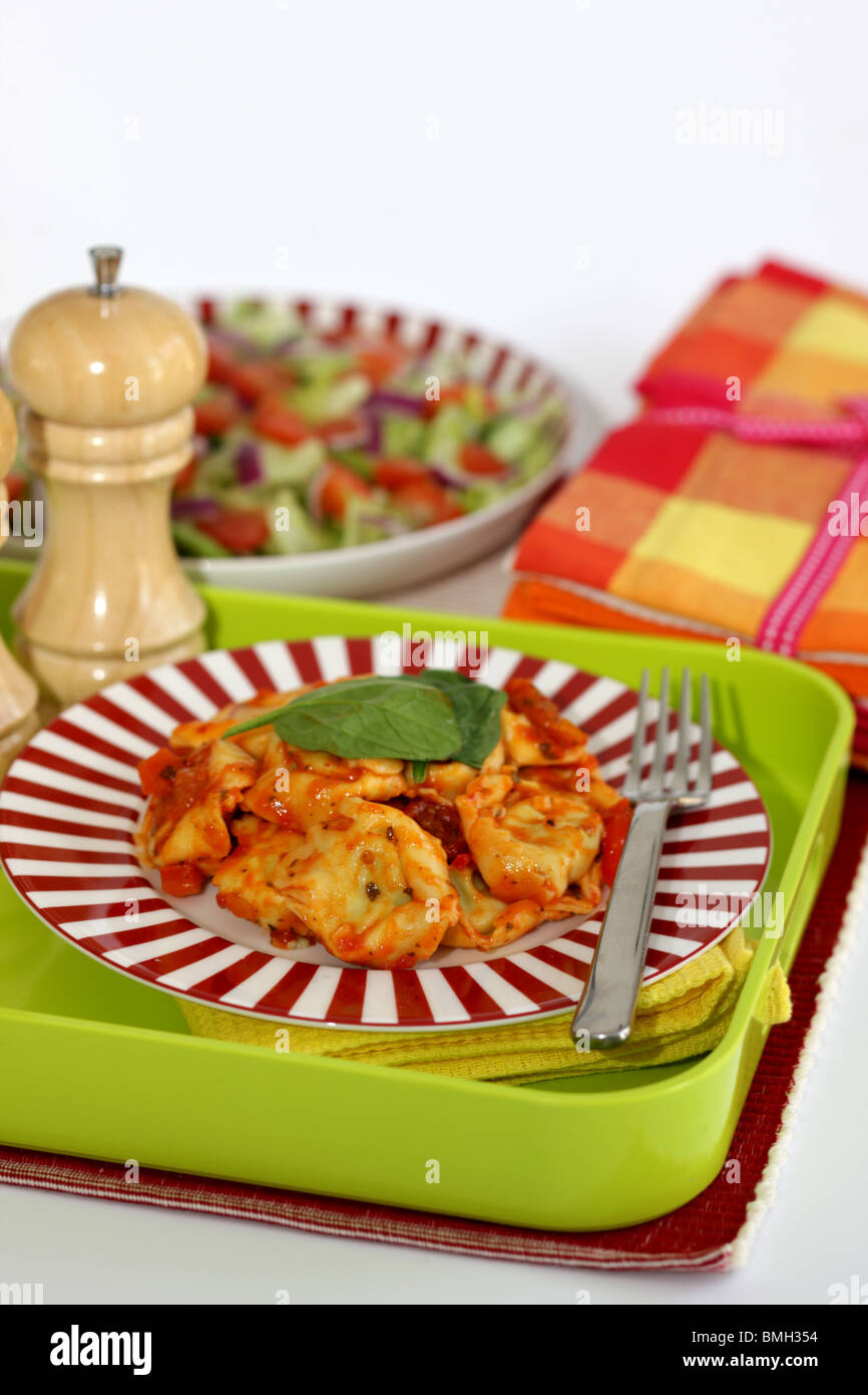 Cucinato al momento in italiano o in stile Mediterraneo autentico di Spinaci e Ricotta Tortelloni con insalata contro uno sfondo bianco con n. di persone Foto Stock