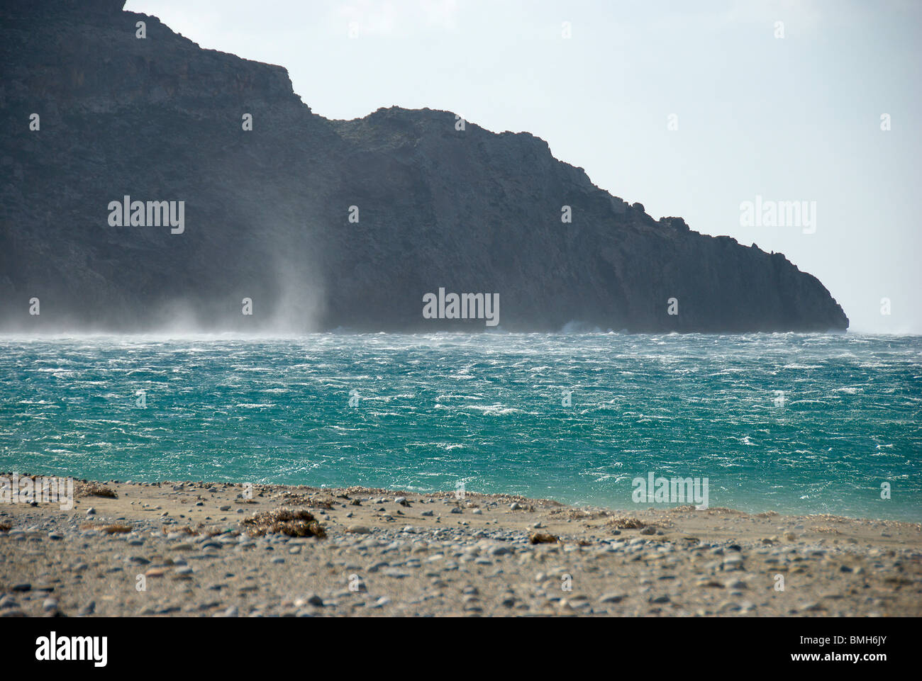 Spazzate dal vento spiaggia cretese con sea spray mantecato fino in aria Foto Stock