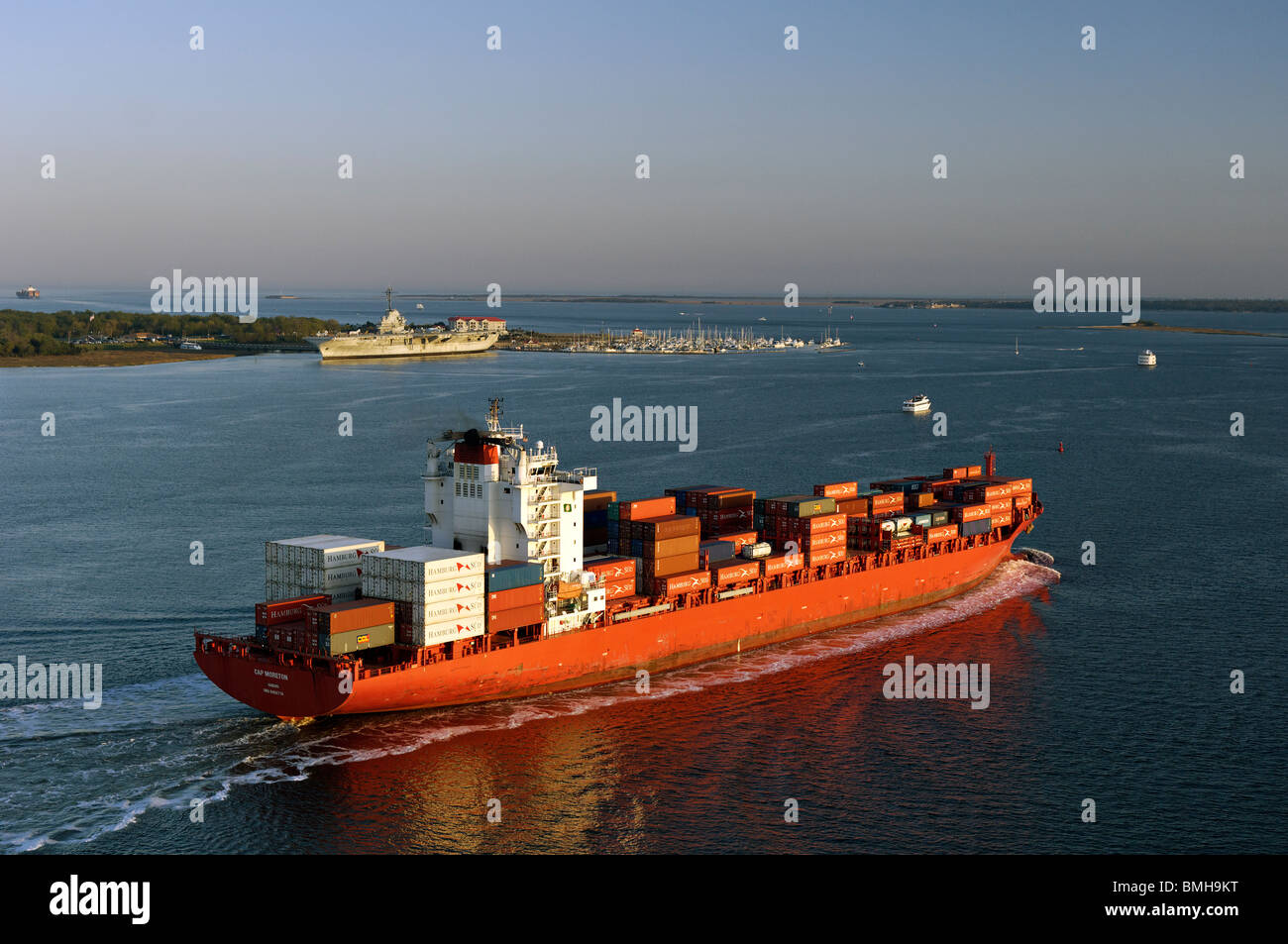 Contenitore nave passando la USS Yorktown con Fort Sumter nella distanza vicino a Charleston, Carolina del Sud Foto Stock