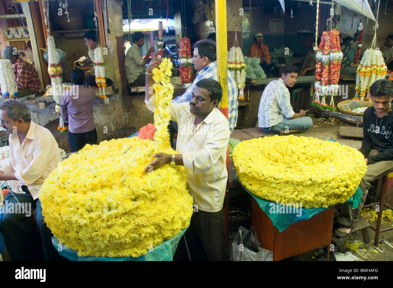 Venditori di fiori crisantemo vendita ghirlande al mercato Devaraja di Mysore India Foto Stock