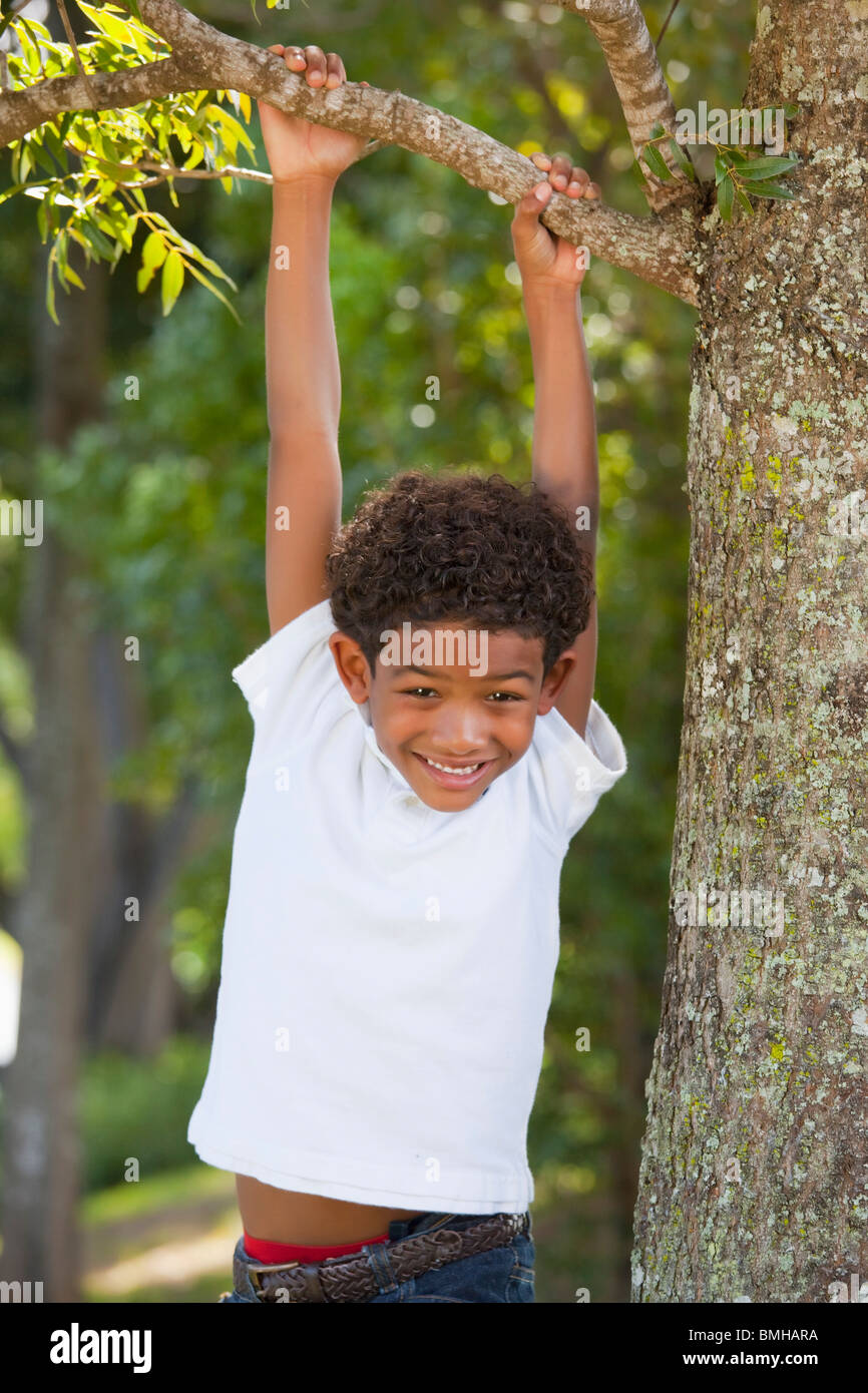Fort Lauderdale, Florida, Stati Uniti d'America; un ragazzo appeso a un ramo di albero Foto Stock