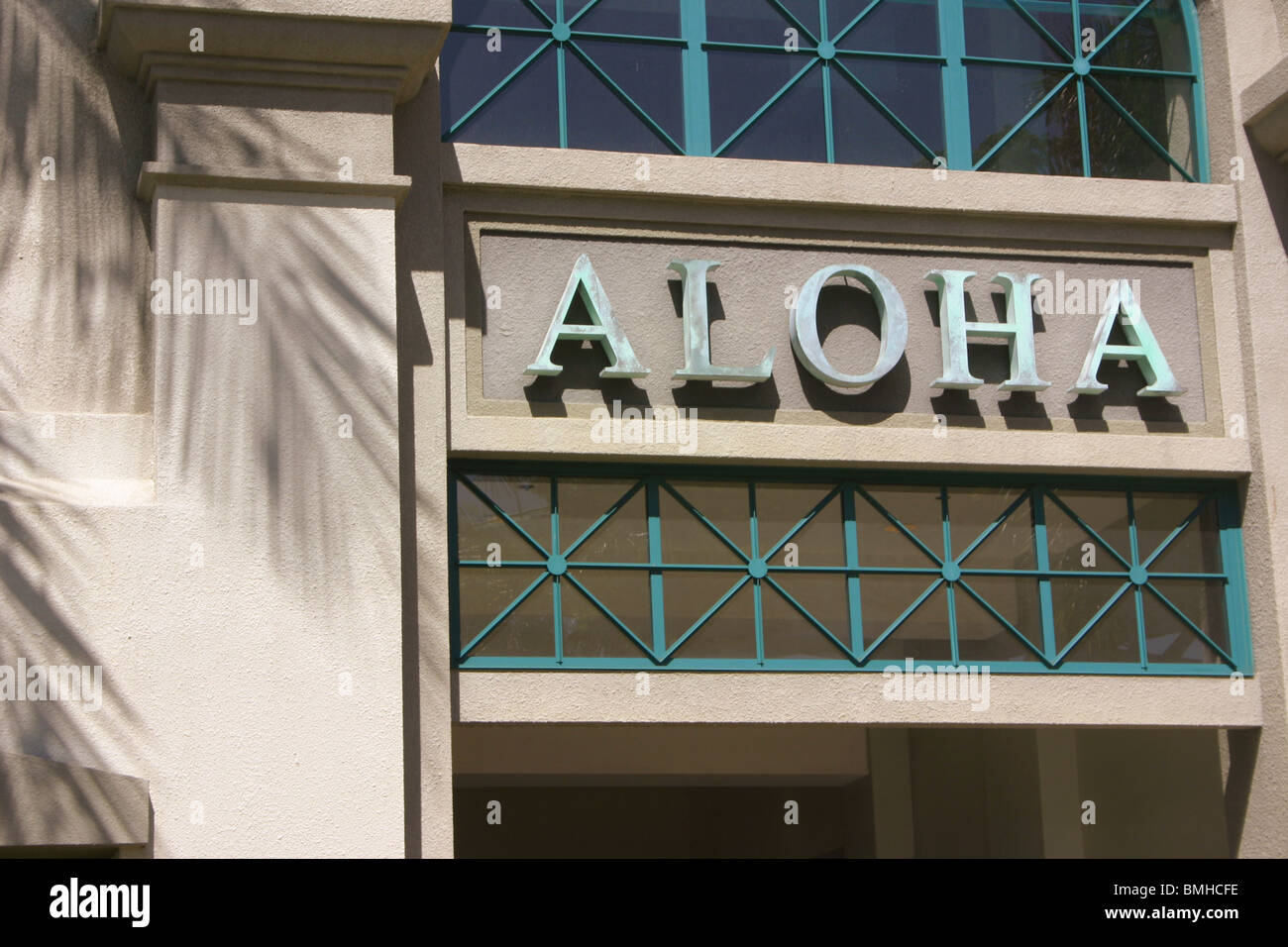 Aloha segno su Aloha Tower con palm frond ombra al tramonto. Honolulu Oahu, HI Foto Stock