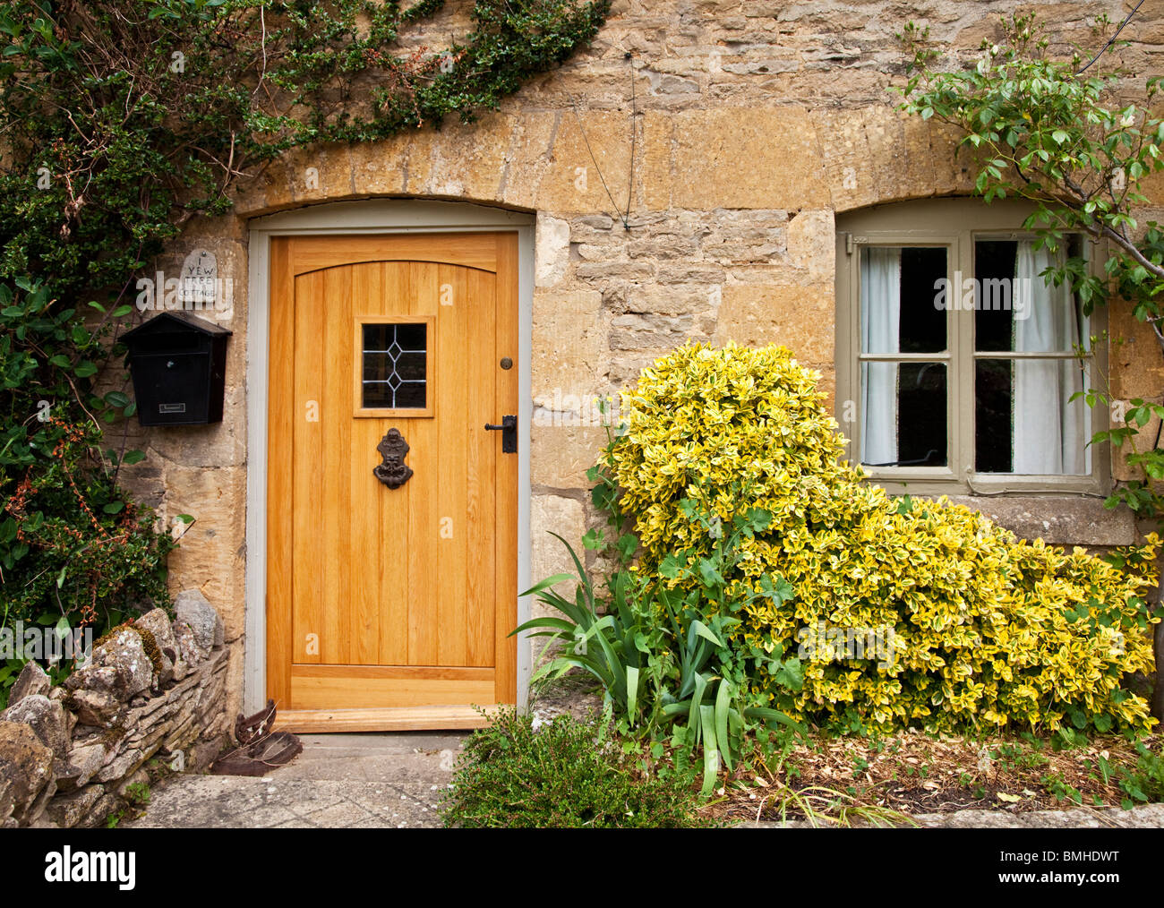 In legno della porta anteriore e la finestra su un tipico Cotswold stone house in Inghilterra, Regno Unito Foto Stock