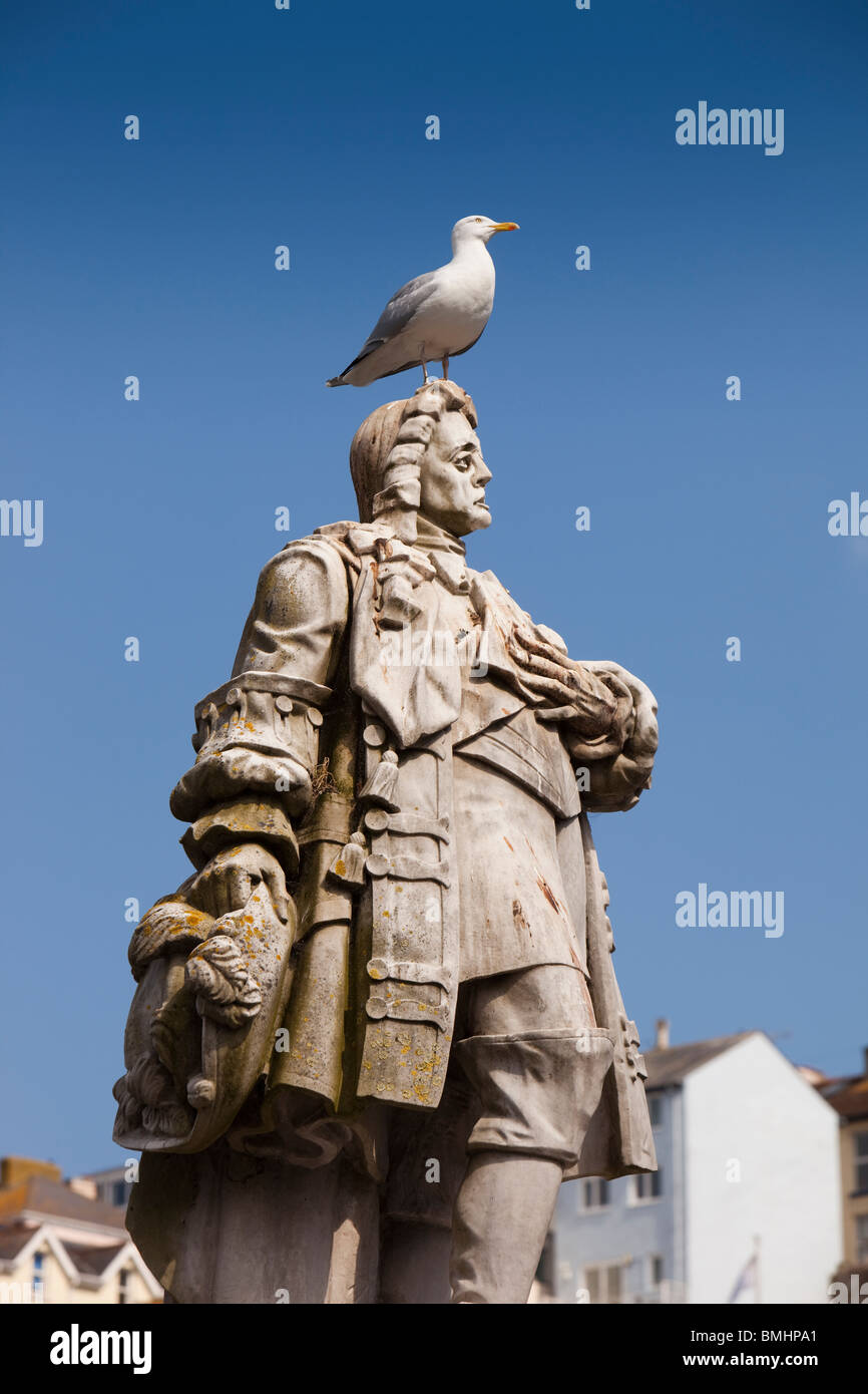 Regno Unito, Inghilterra, Devon, Brixham Harbour, sea gull permanente sulla sommità del principe William della statua di colore arancione Foto Stock