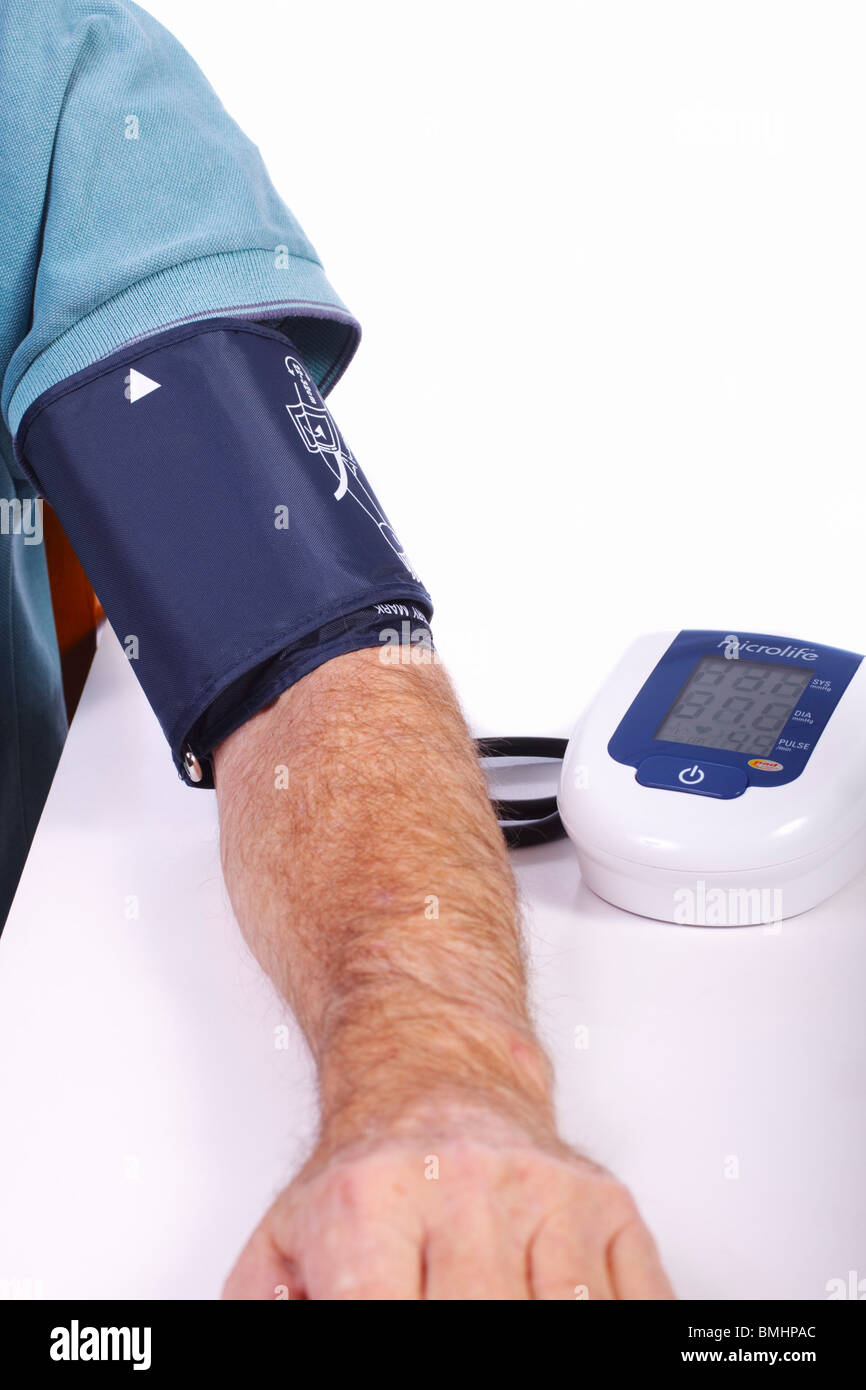 Maschio con sangue misuratore di pressione attaccato al suo braccio. Foto Stock