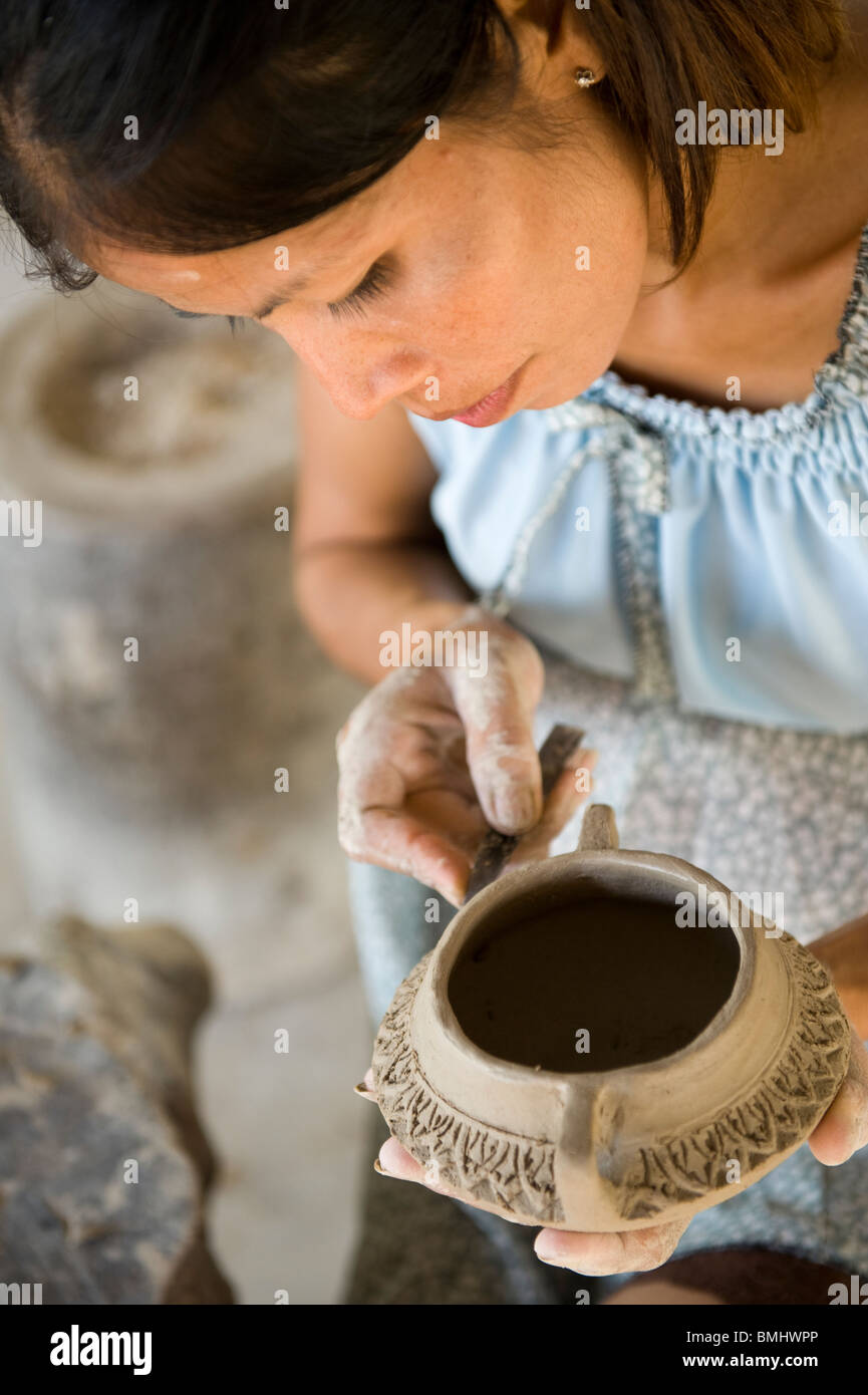 Lavoratrice gestante carving un tradizionale Khmer cambogiano pot pronti per la cottura in Siem Reap Cambogia. Foto Stock