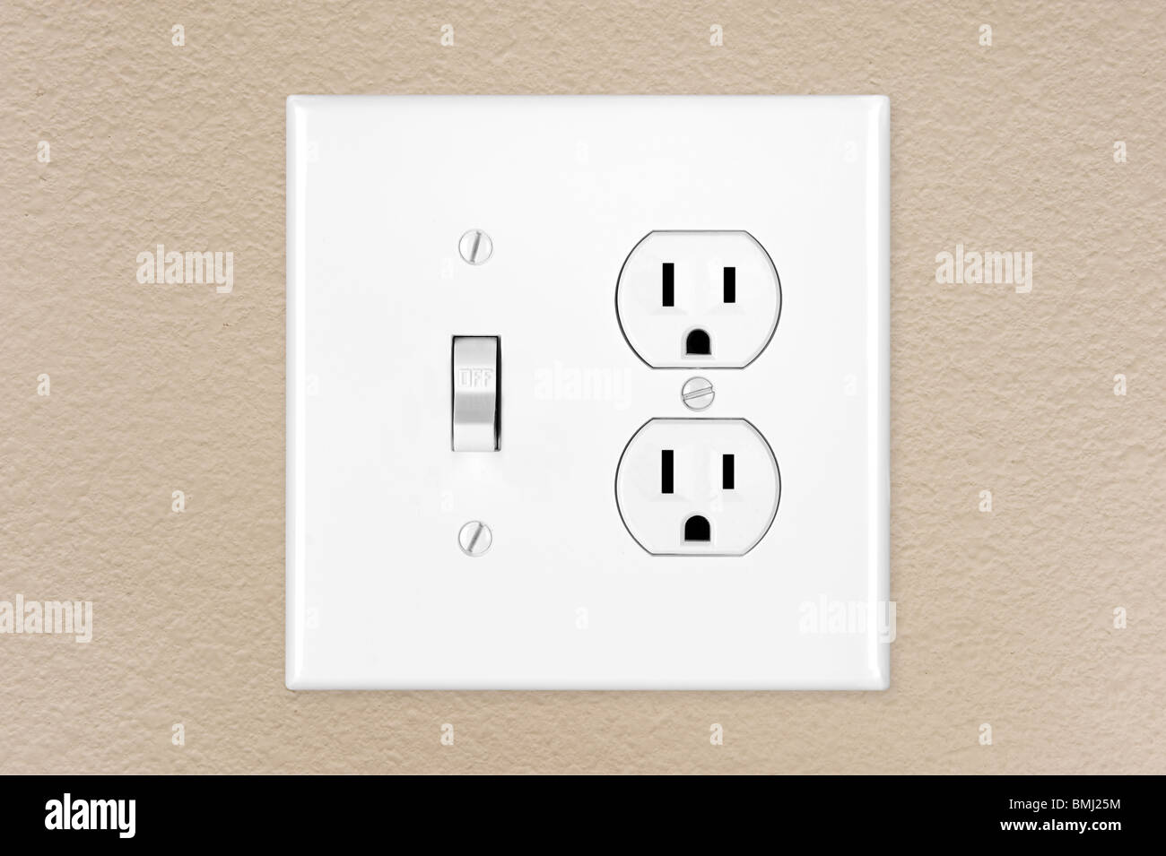 Un moderno nuovo di zecca toggle elettrico interruttore della luce e presa di corrente su un dipinta di fresco parete. Foto Stock