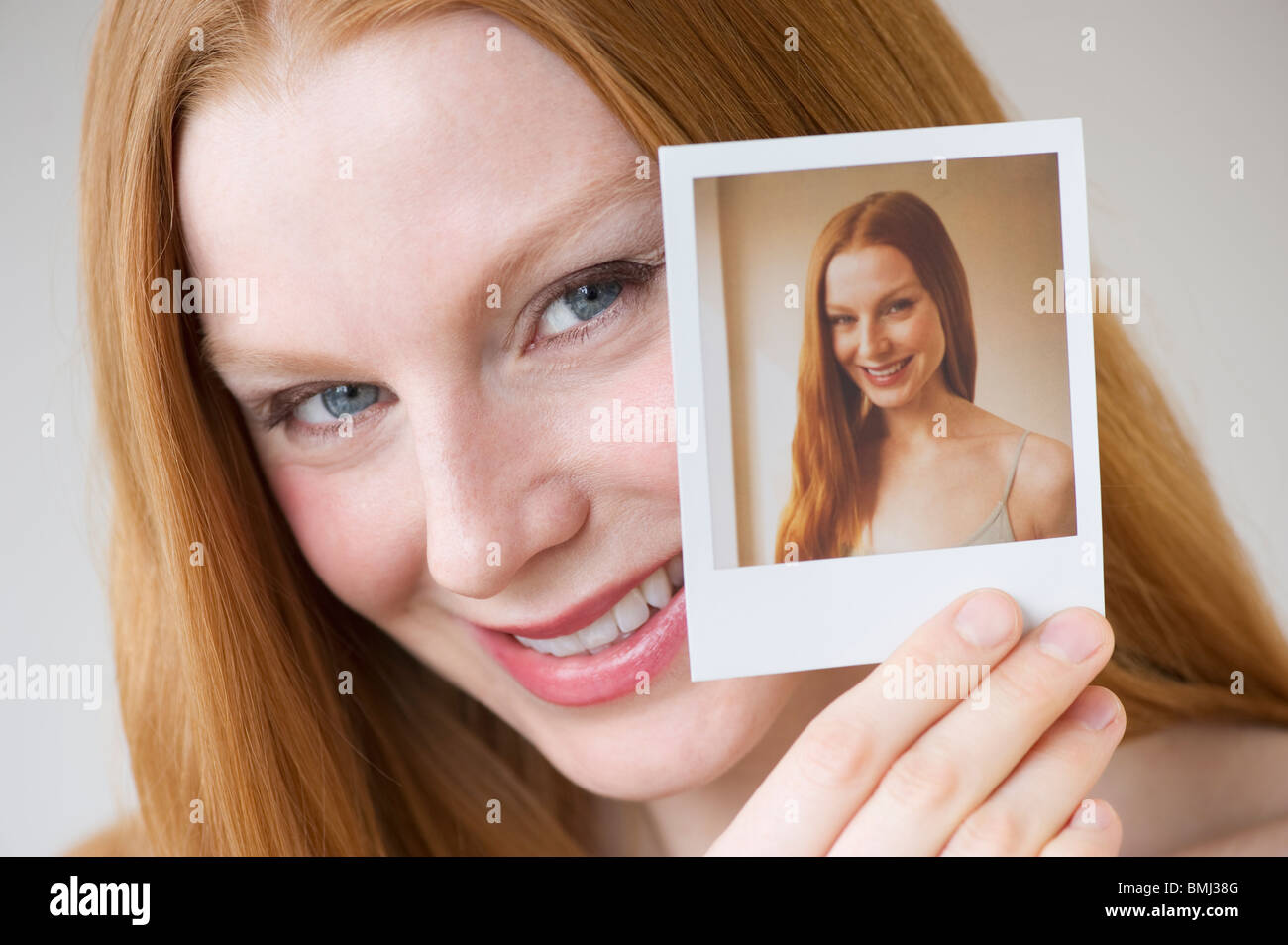 Donna che mantiene una fotografia di se stessa Foto Stock