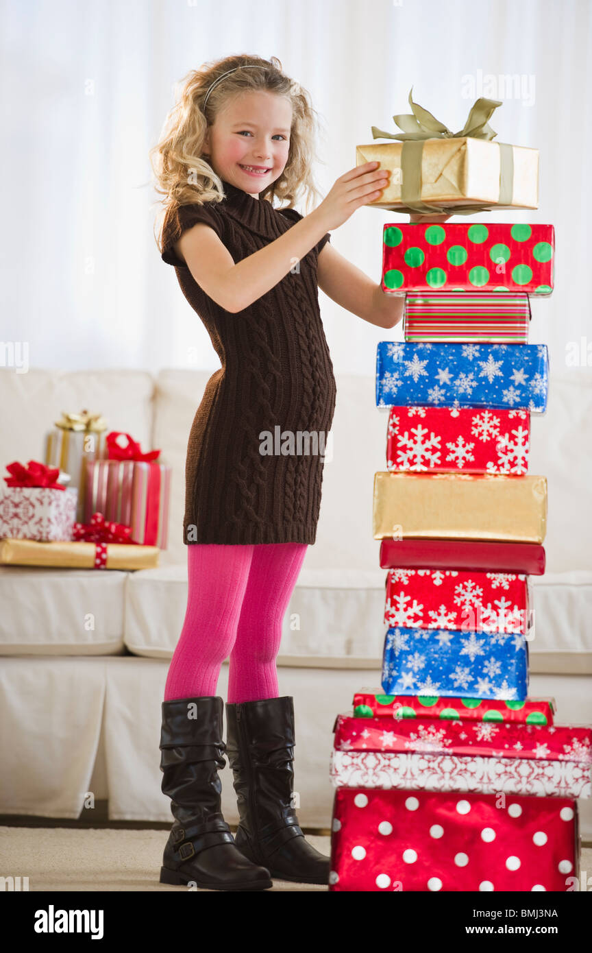 Ragazza giovane di impilamento di regali di Natale Foto Stock