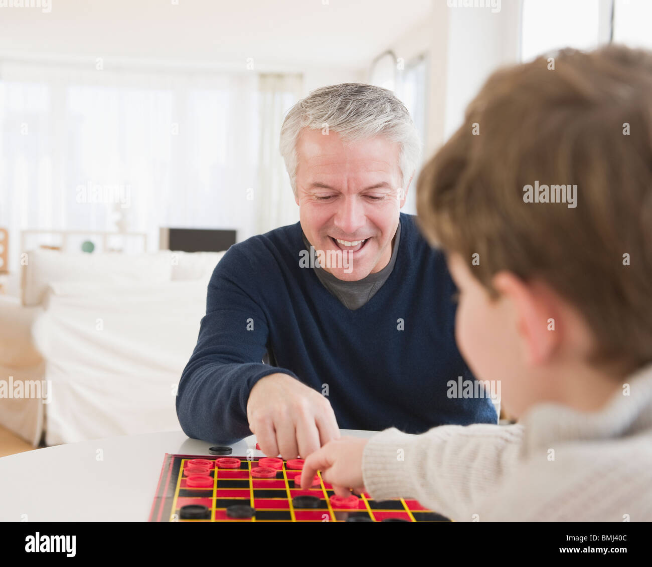 Padre e figlio giocando a Dama Foto Stock