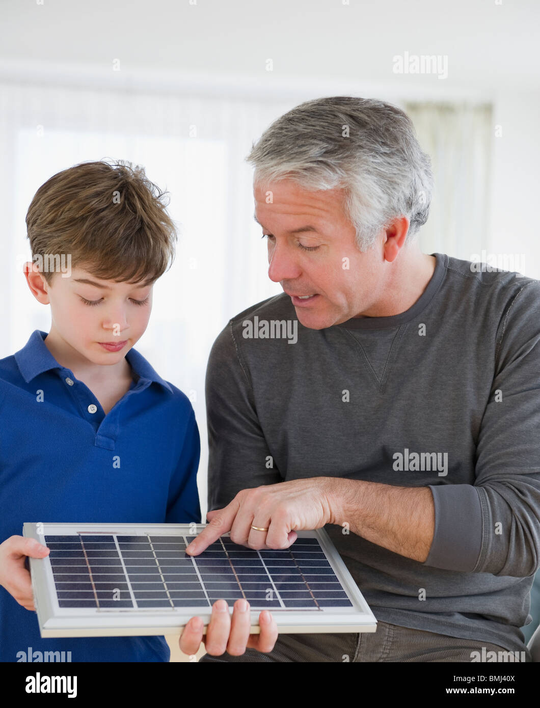 Padre mostra pannello solare al figlio Foto Stock