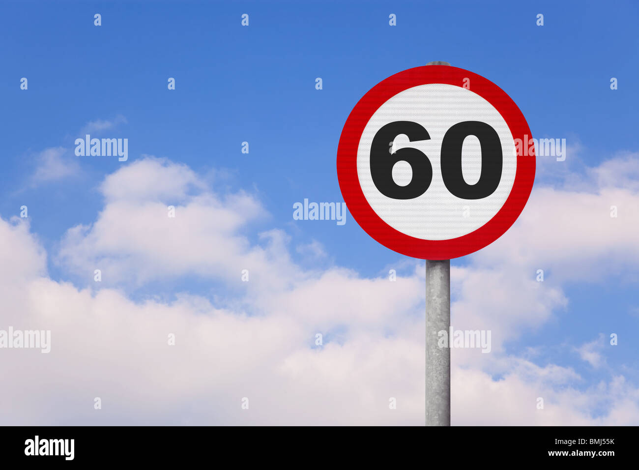 Un round cartello stradale con il numero 60 su di esso contro un blu cielo nuvoloso. Foto Stock